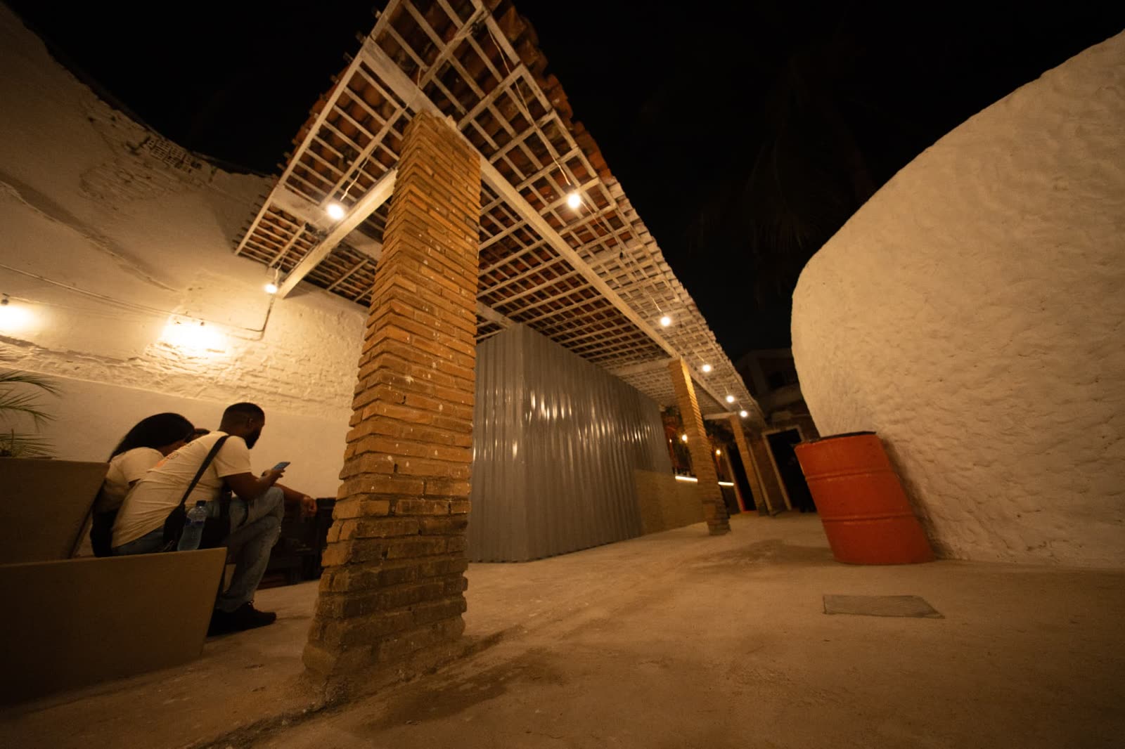Área externa da Hype House com pergolado e iluminação